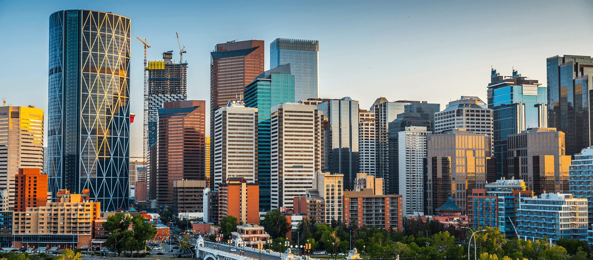 Calgary skyline with modern skyscrapers at sunset.