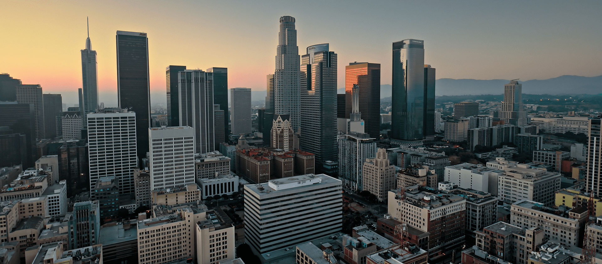 City skyline at sunset with tall buildings.