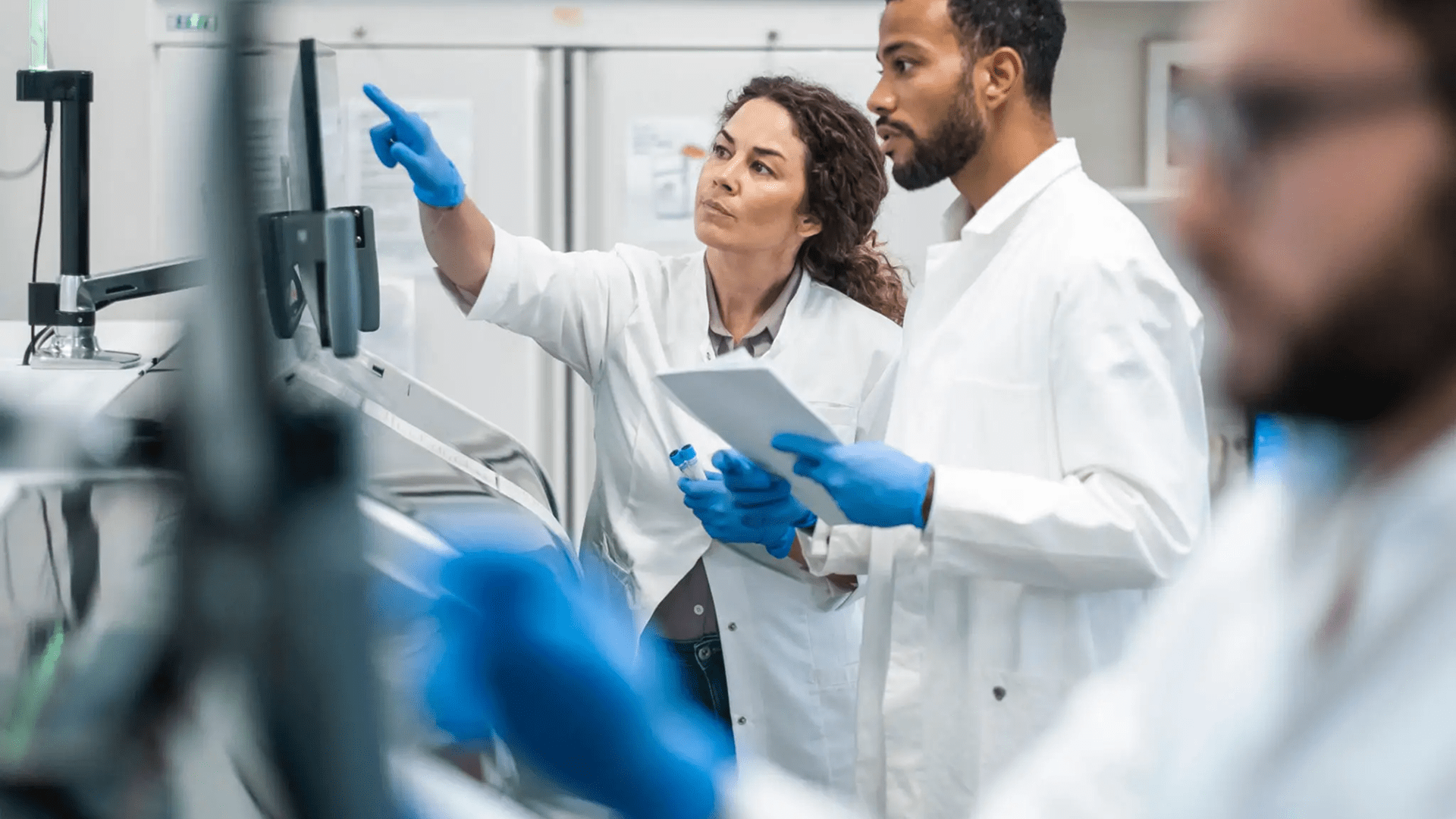 Scientists discussing data in a laboratory setting.