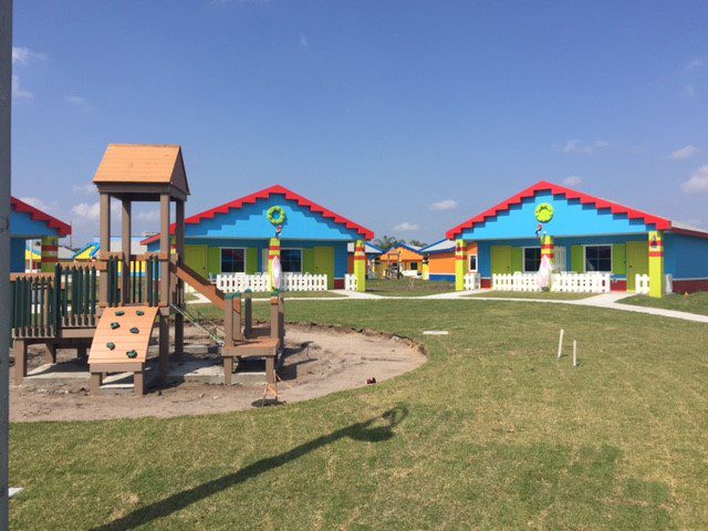 Playground with colorful houses and clear blue sky.