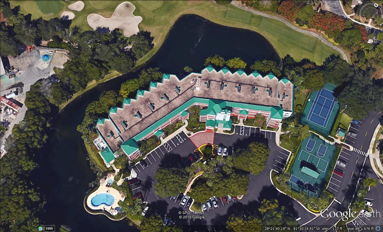 Aerial view of a resort with pools and lush greenery.