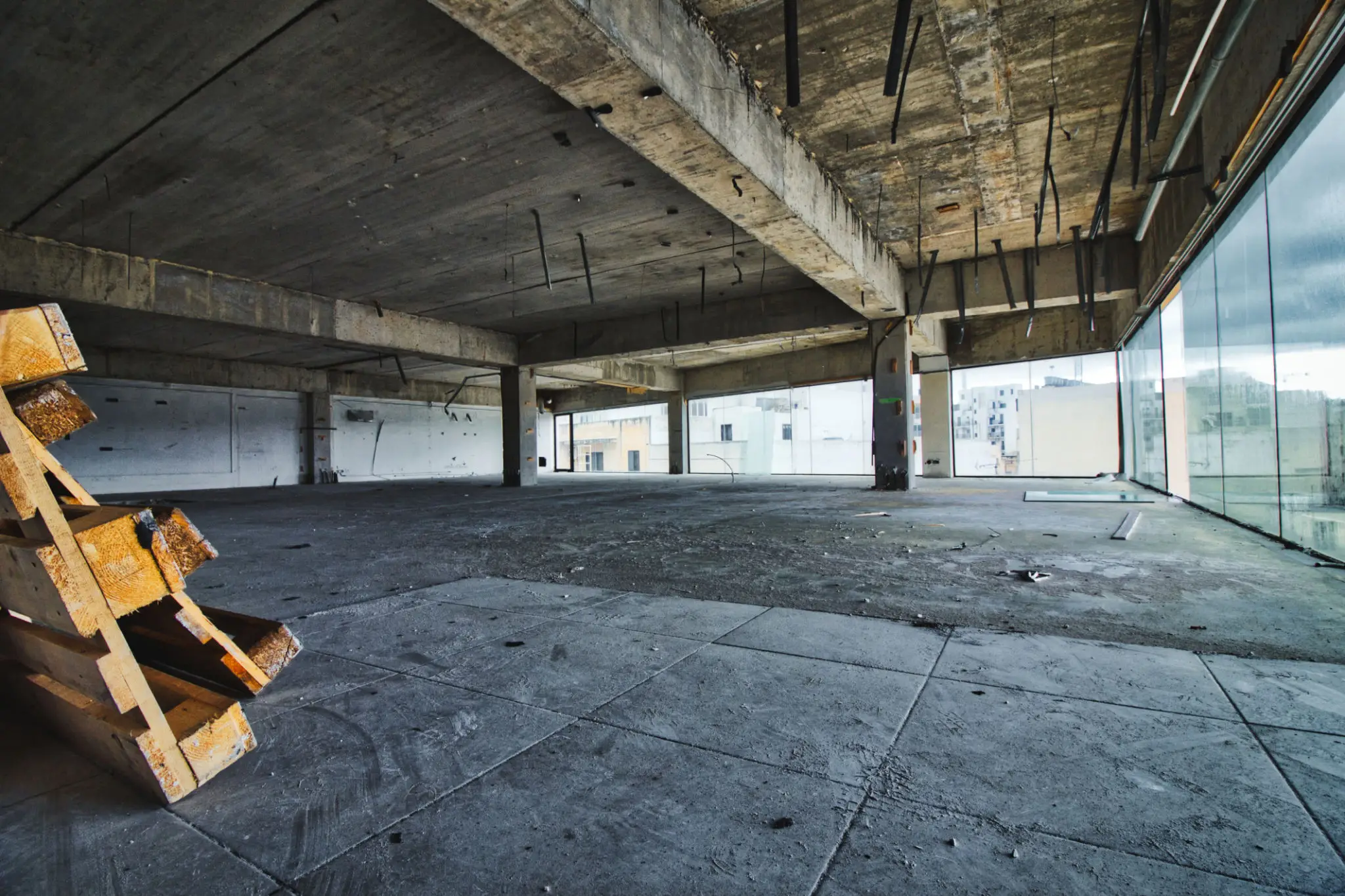Empty concrete warehouse with large pillars and open spaces.