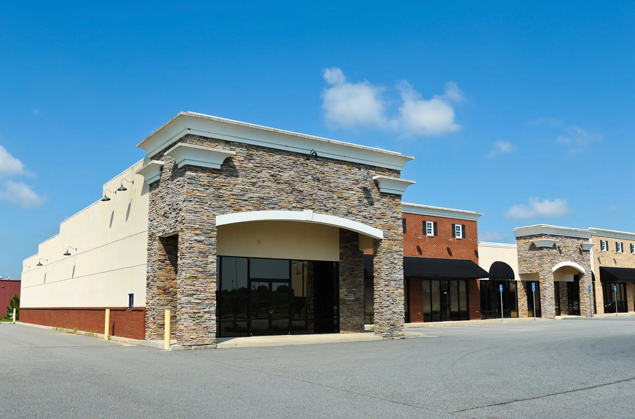 Empty shopping plaza with clear blue sky.