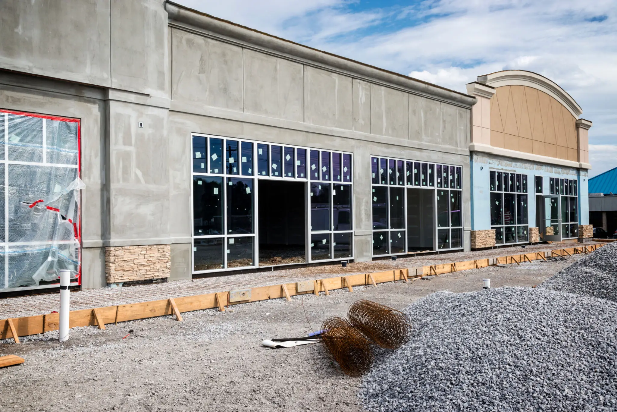 A commercial building under construction with large glass windows.