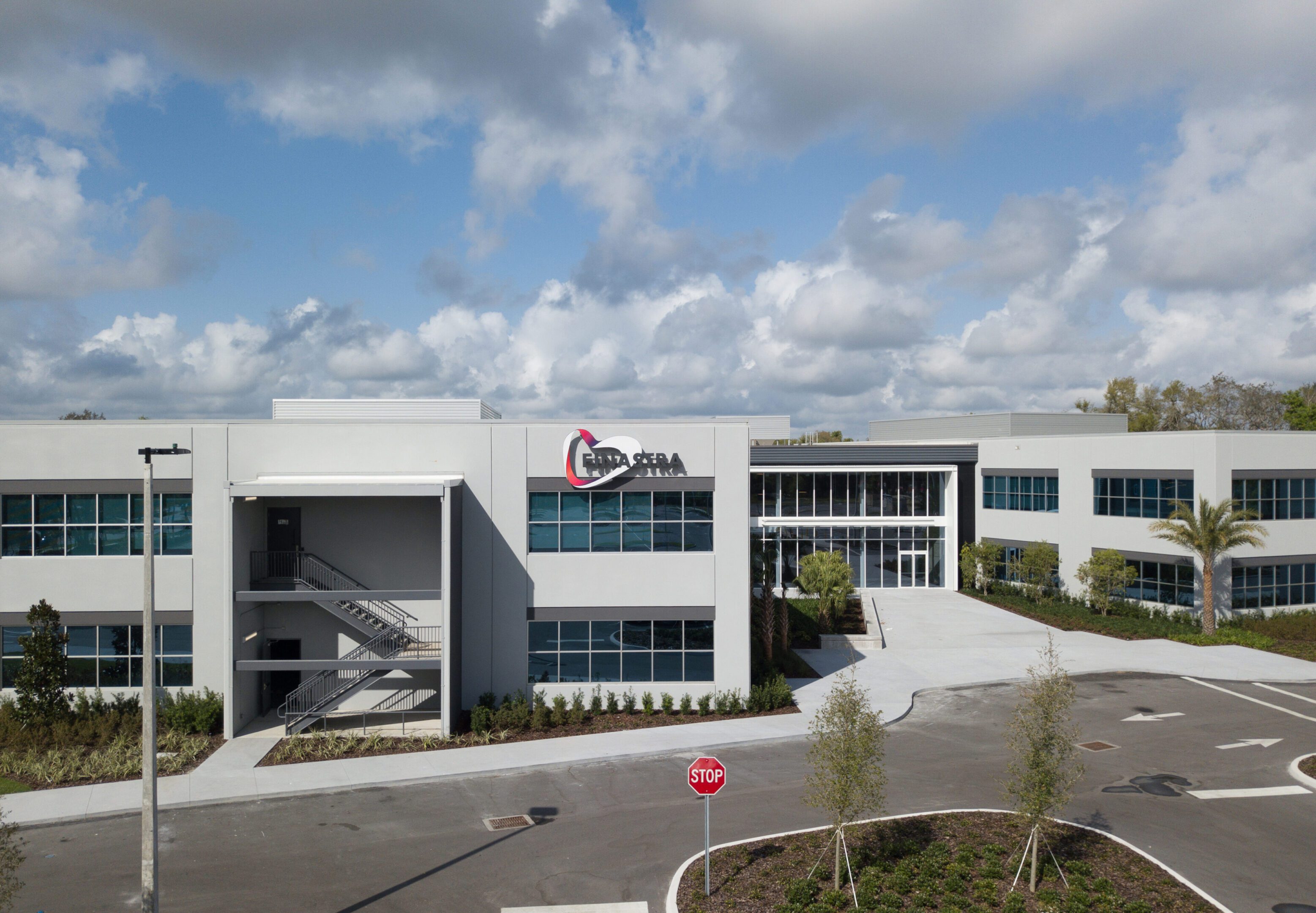 Modern office building with clear skies and a parking area.