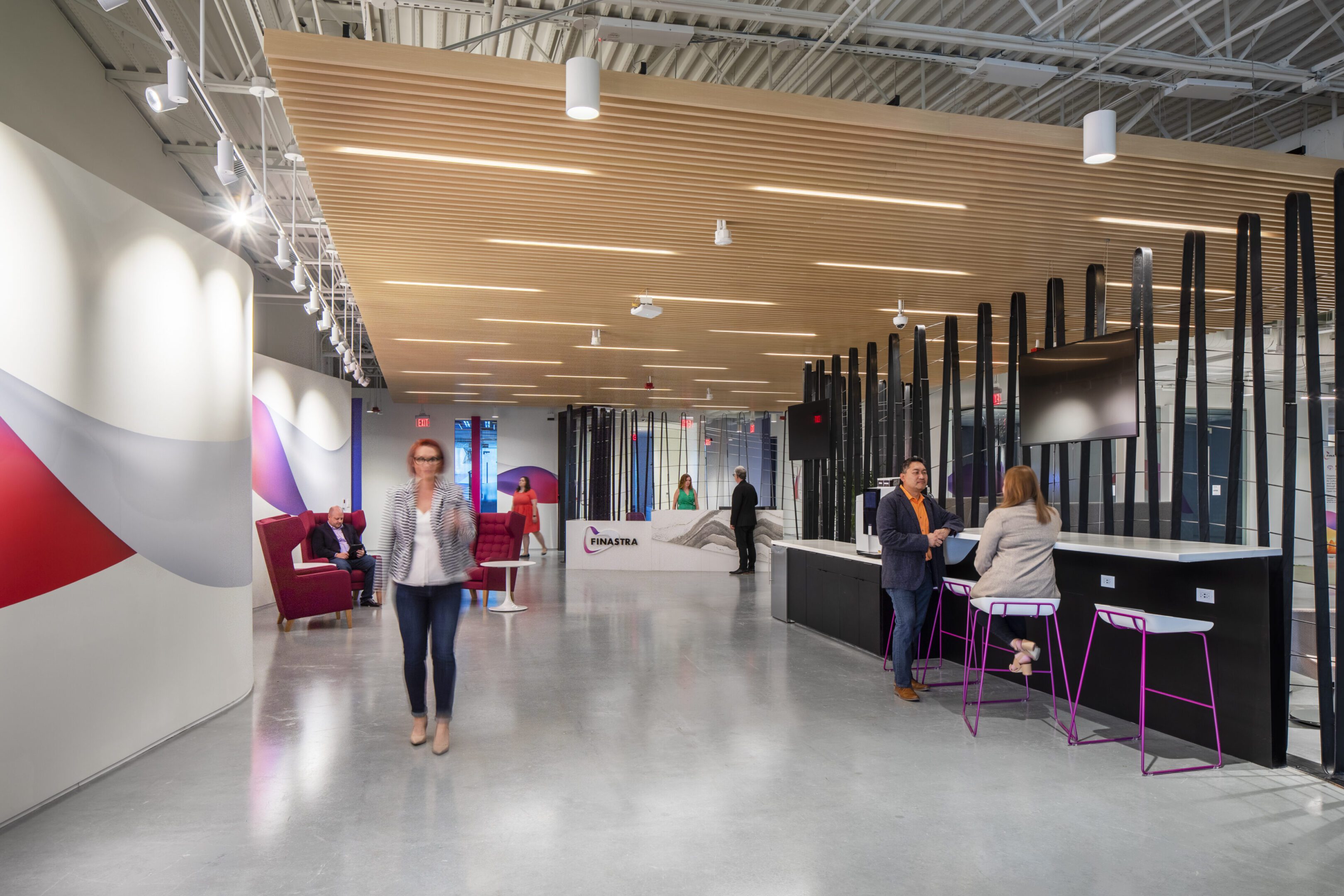 Modern office space with people working and walking.