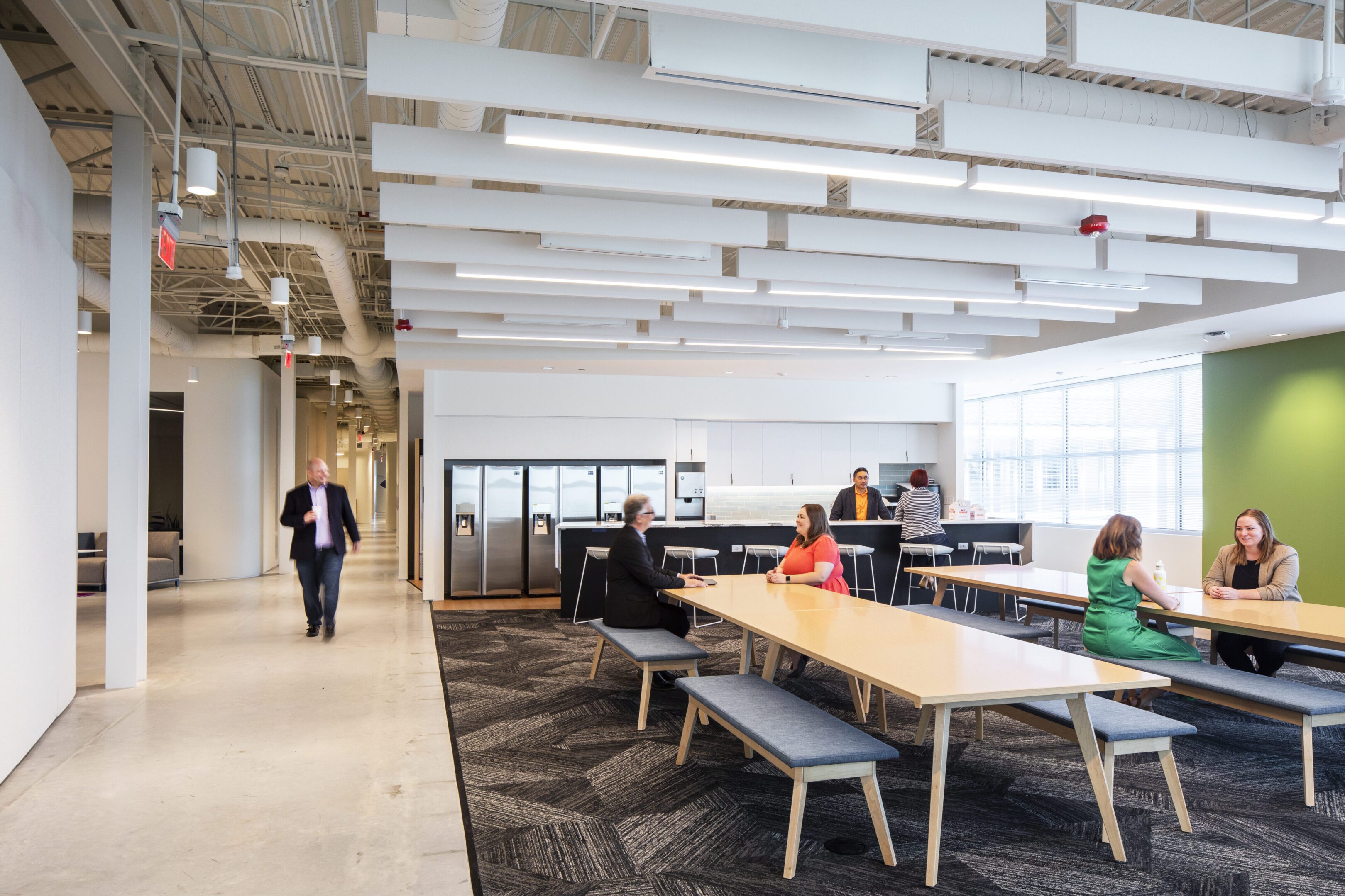 Modern office space with people working and walking.