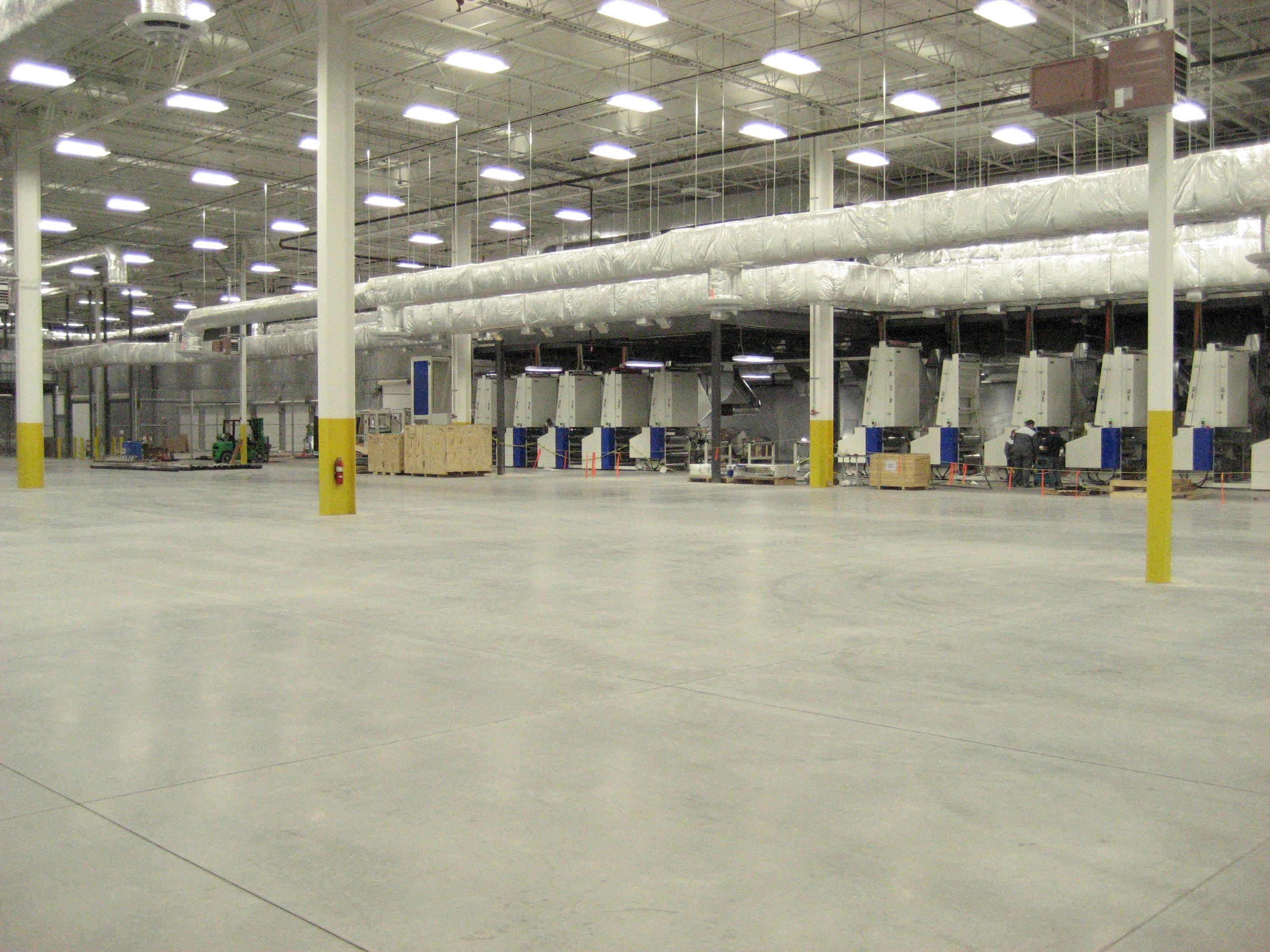 Spacious industrial warehouse with polished concrete floors and overhead lighting.