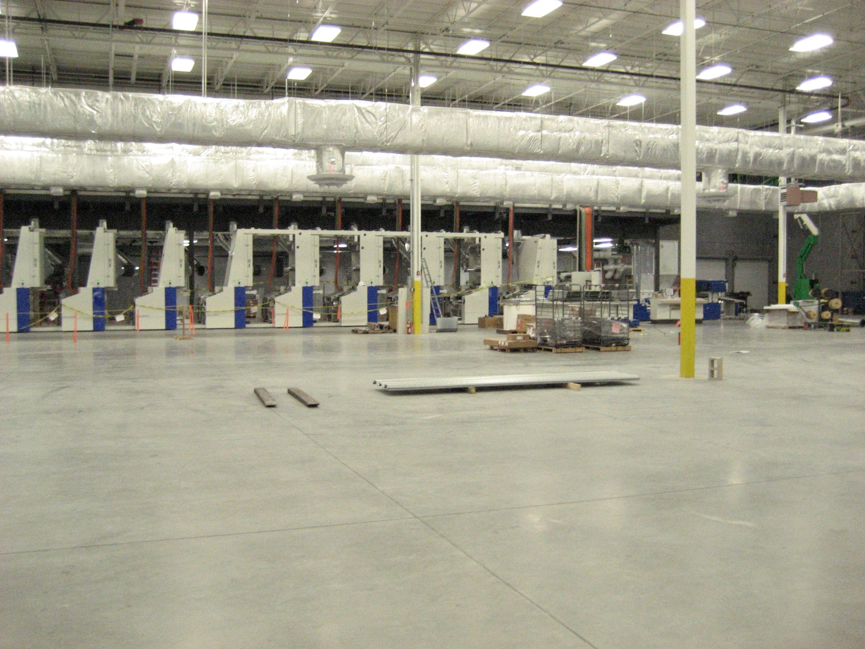 Empty warehouse interior with loading docks and forklifts.