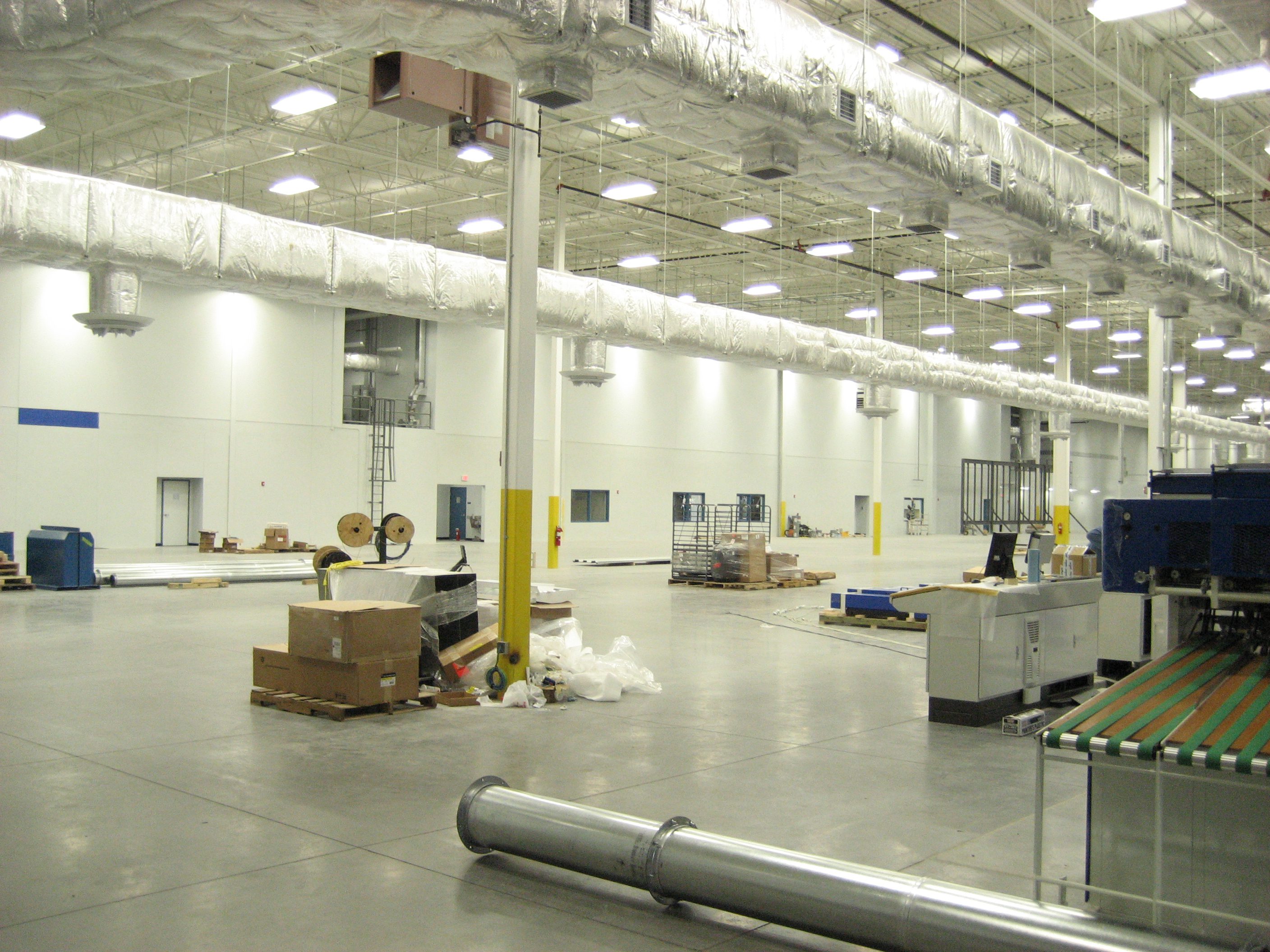 Spacious industrial warehouse with equipment and materials.